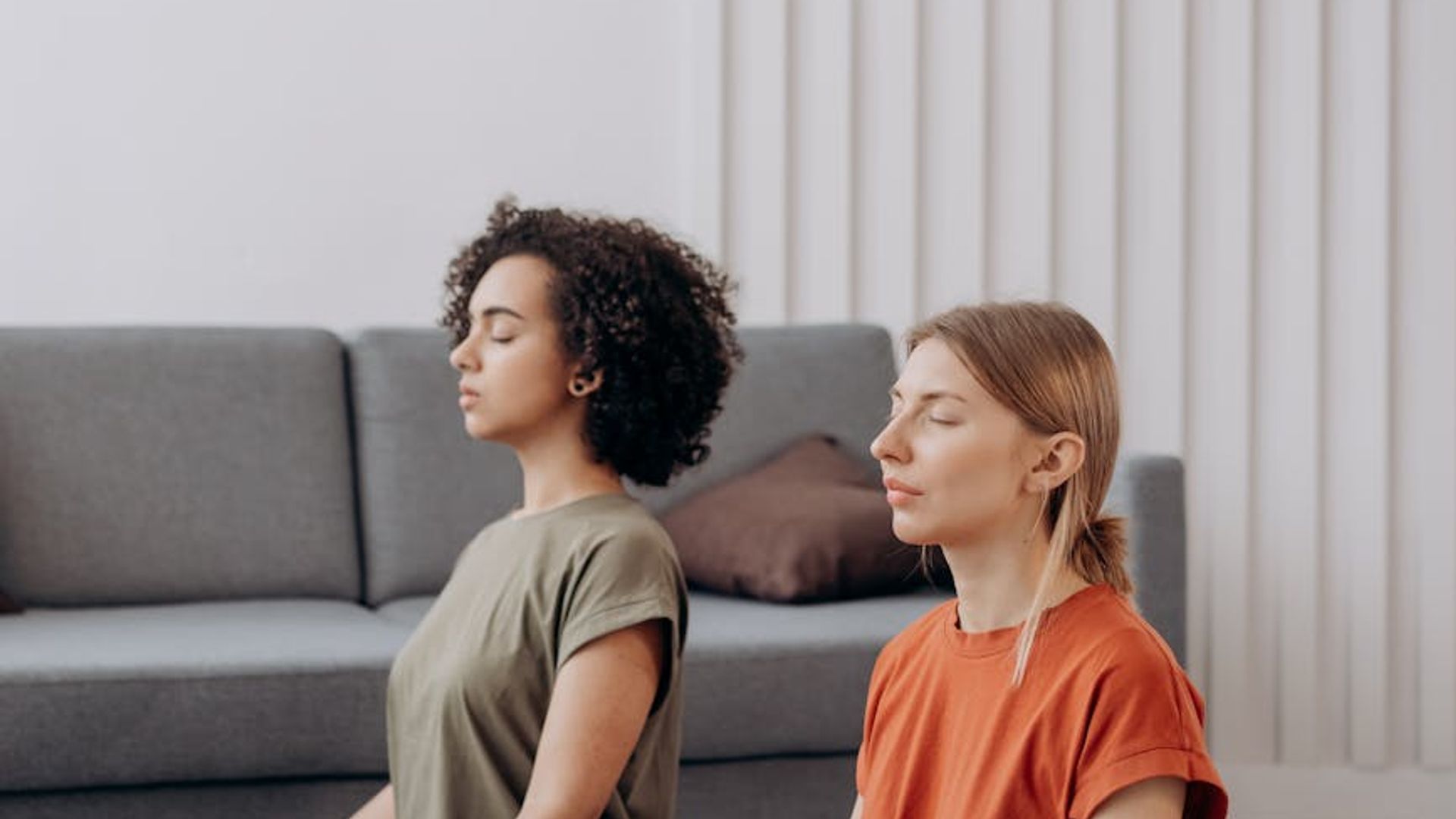 Calm and focused person practicing yoga in a minimalist dark room.